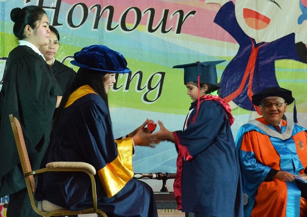 Dr. Goh Hui Chyn issues graduation certificates to students.